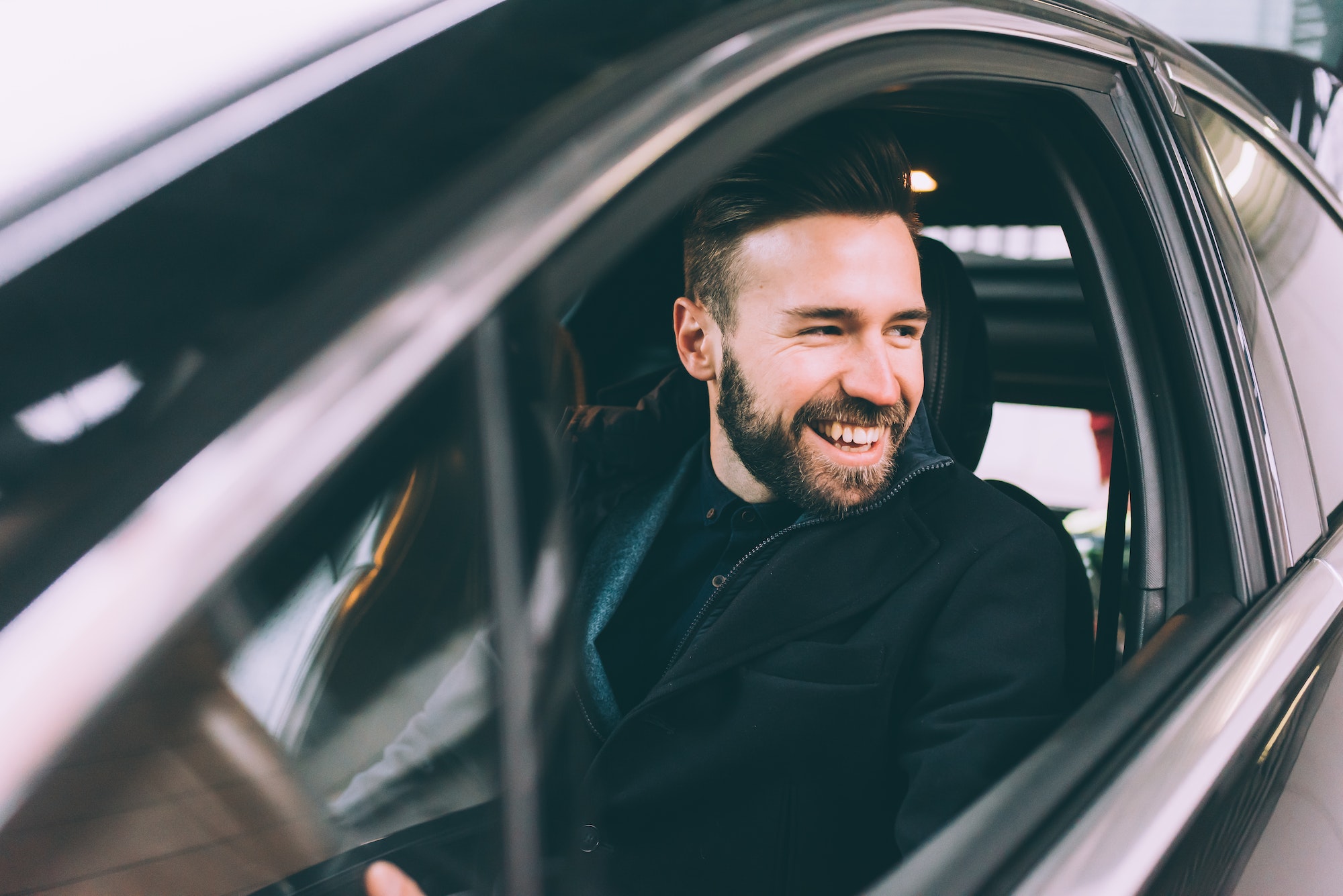 young bearded businessman sitting car