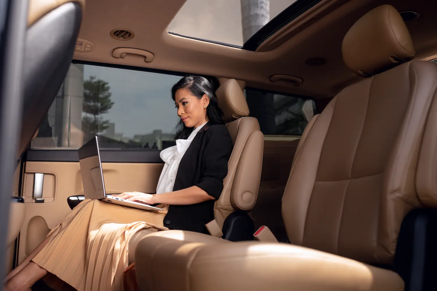 Businesswoman seated in the back of a chauffeured executive sedan in Seattle
