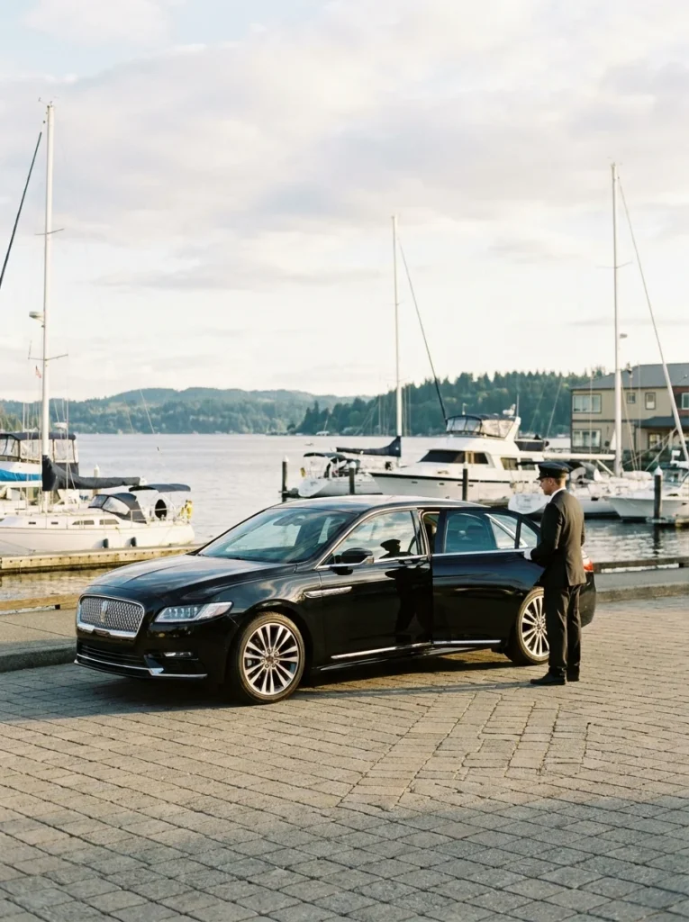 Black Lincoln Continental with chauffeur beside the Kirkland marina on Lake Washington
