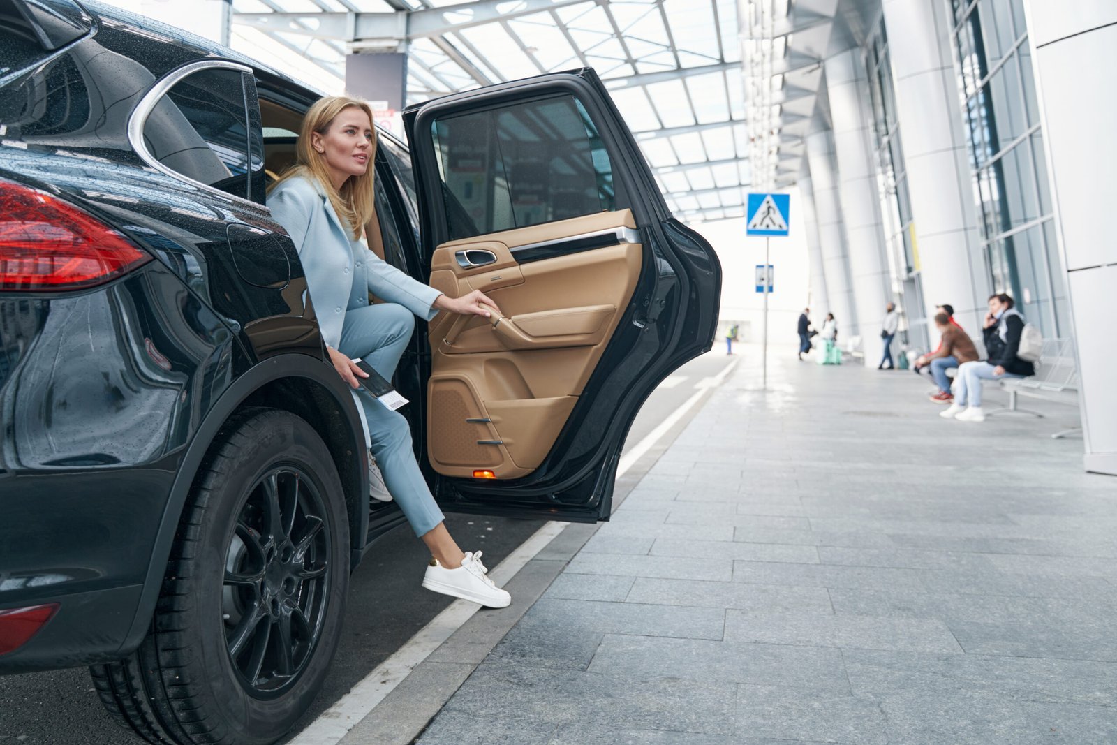 Passenger stepping out of a chauffeured sedan on a private Seattle airport transfer